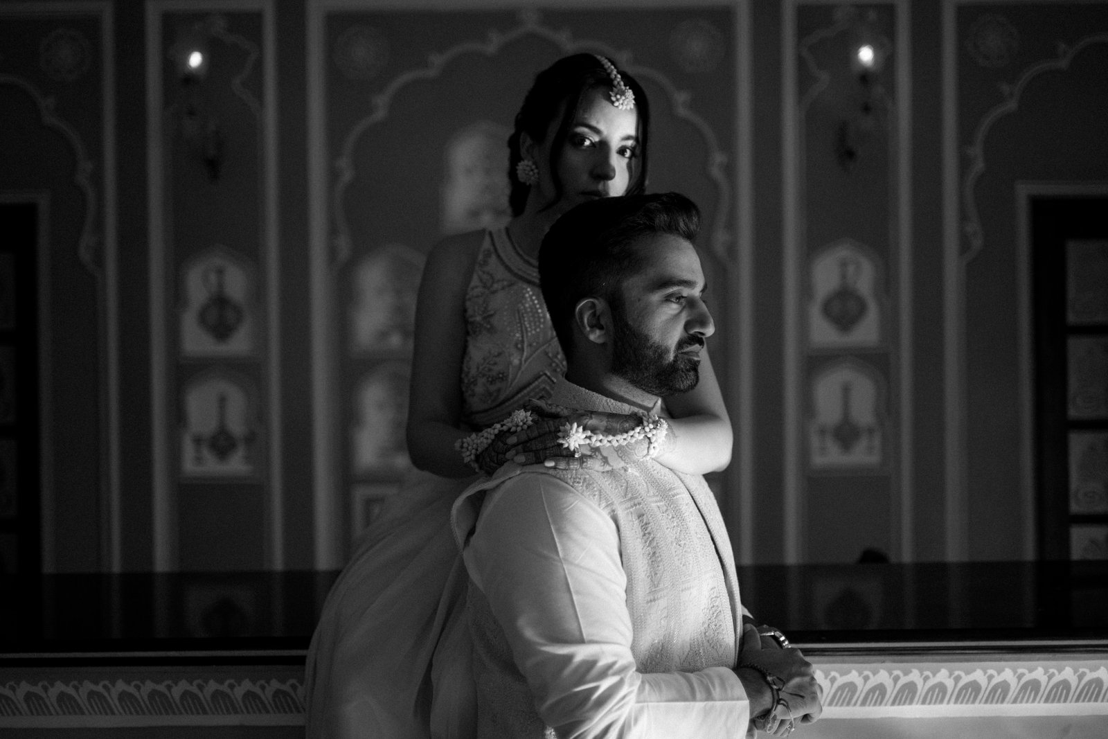 Couple sitting on the floor by a sofa in low, moody light